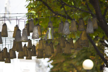 Naklejka premium several homemade bells hang on the street overhead in the city. south of russia, summer. The music of wind.