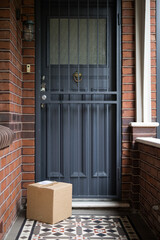 A parcel delivery of a brown cardboard box containing goods purchased online and delivered...