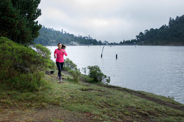 Atleta corriendo al aire libre cerca de un lago con montañas al fondo