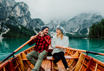Titolo: Romantic couple on a boat visiting an alpine lake at Braies Italy. Tourist in love spending...