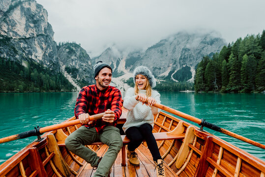 Titolo: Romantic couple on a boat visiting an alpine lake at Braies Italy. Tourist in love spending loving moments together at autumn mountains. Concept about travel, couple and wanderust.

