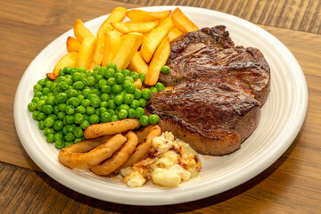 Steak Dinner - Rump steak, with chips, peas onion rings and cauliflower cheese.