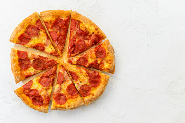 Peperoni pizza on a light table. Horizontal orientation, top view, copy space.