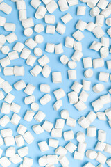 Marshmellow texture, Pattern. White sweet marshmallows on blue background flat lay top view. Winter or autumn food concept, New Year's or Christmas sweetness, candy, dessert. Minimalistic style