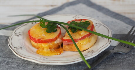Natural healthy food. Sandwiches on a wooden white plate.Hot homemade sandwiches with sausage, tomatoes and cheese.