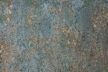 Old sheet metal with cracked gray and blue paint. Rust is visible in the cracks. The texture is like a mosaic. Background.