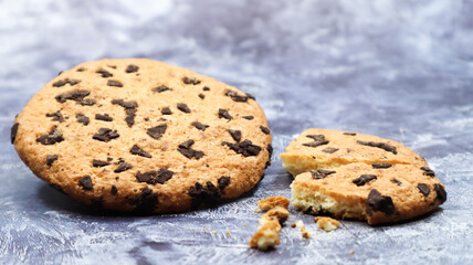 One soft, freshly baked chocolate chip cookie on a gray marble kitchen countertop. American traditional dessert. Delicious sweet food. Homemade baking concept for the holiday. Culinary background