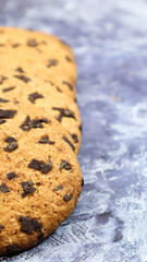 Soft, freshly baked chocolate chip cookies on a gray marble kitchen countertop. American traditional sweet pastry pastry, delicious homemade dessert. Culinary background. Vertical photography