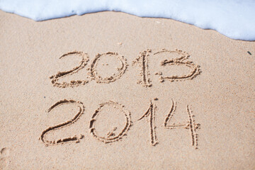 2012 and 2013 written in sand on beach