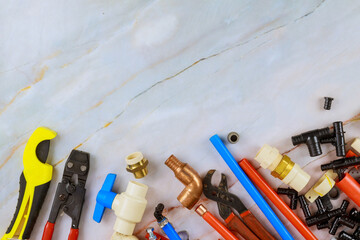 Plumbing tools, pipe fittings on a home improvement plumbing materials including copper pipe, elbow joint, wrench and spanner.