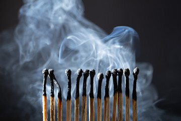 Burned, extinguished matches isolated with smoke on black background, clipping path