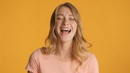 Pretty cheerful girl laughing at something funny over colorful b