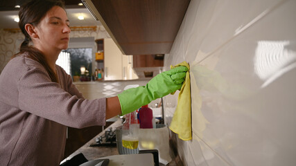 Girl washes tiles in the kitchen