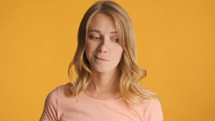Fototapeta premium Doubtful girl thinking on camera over colorful background. Thoug