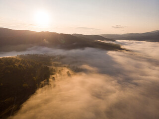 Obraz na płótnie Canvas Aerial view of autumn sunset in mountains with fog and cloud landscape