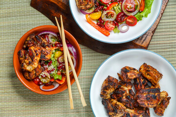 Plates of Pan-Asian sesame salad and grilled chicken pieces in Pad Thai sauce.
