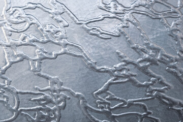 Patterned abstract glass or molten metal flows textured background.