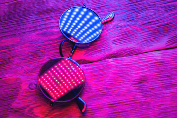 A black circle sunglasses in the neon lights background.