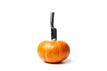 A pumpkin cooked to make a halloween lantern, and a sharp knife for making a face