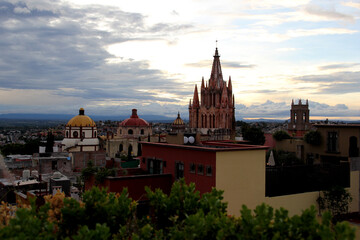 Naklejka premium view of dome, cathedral towers and town of San Miguel de Allende at sunset and night in Guanajuato Mexico