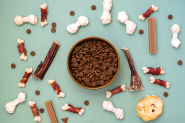 Dog delicacy food and feed in bowl on green background. Variety of dog treats.
