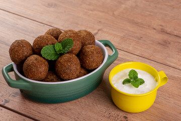 a portion of kibbeh and a little curd with a sprig of mint