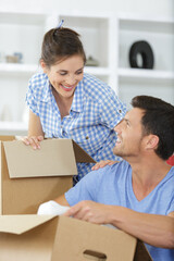 couple unpacking boxes with property