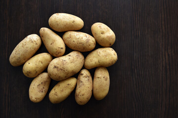 Potatoes on a wooden table. Copy space is on the right side.