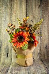Orange decorative sunflower and two acorns isolated on the wood background