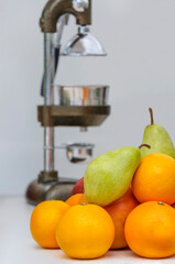 Fresh fruit oranges, pears and grapefruit. In the background a hand press for citrus.