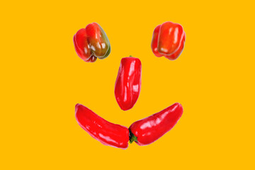 sweet pepper, smil laid out of red sweet pepper, funny face of red pepper on a yellow background