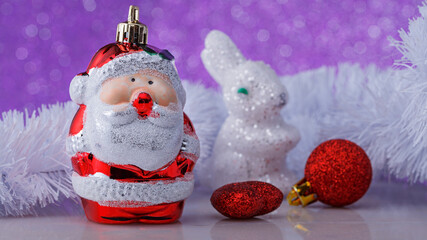 Christmas composition with toy Santa Claus and toys on a colored background