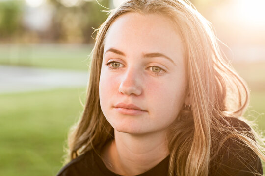 Teenage girl looking wistful,with sun flare