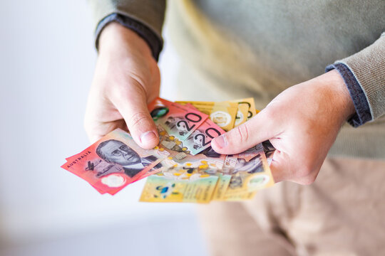 Man holding out fifty and twenty dollar notes australian currency
