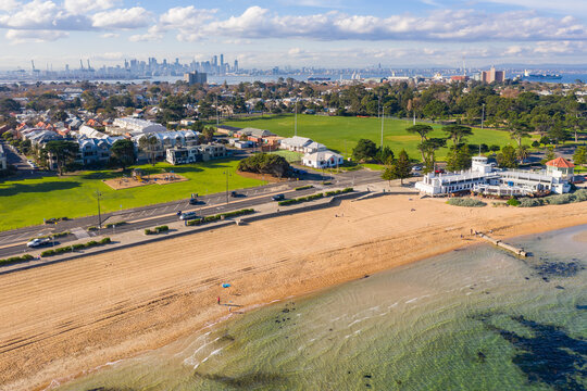 Aerial view of a bay side beach with surrounding parkland and sporting reserves