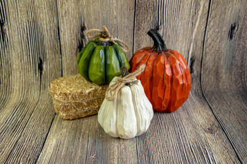 Autumn decorations with the diffrent color of pumpkins idoltaed on the wooden background.