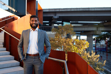 Indian businessman with open collar cheerful outdoors in city