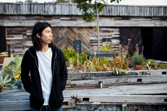 Young Asian man standing outside in warehouse courtyard