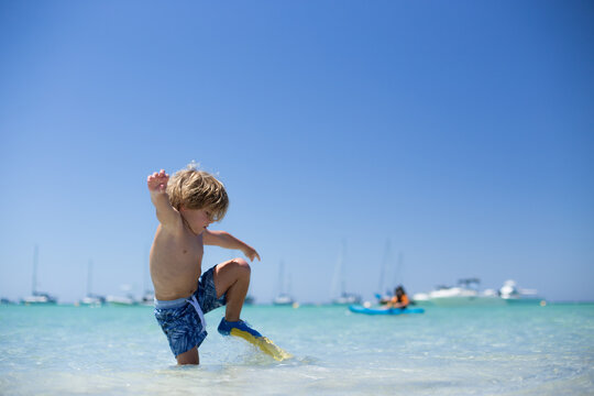 Boy wearing flippers playing in sea