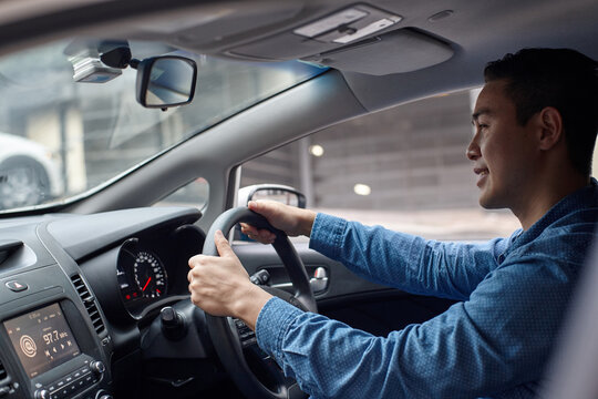 Asian man driving in car