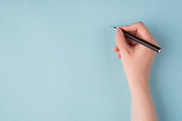 Top above overhead close up first person view photo of girl's right hand holding black pen starting...