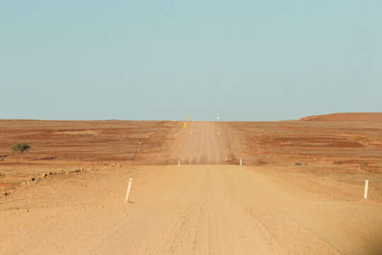 Wide outback dirt road with blue sky