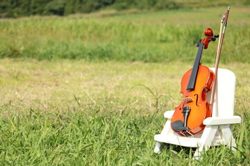 草原に置かれたイスの上のヴァイオリン violin on the small chair  on the grassland 3
