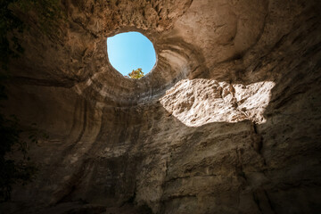 A hole from which the sun's rays and the sky are visible outside of an underground cave, an abnormal natural phenomenon in the rocks in the Crimea
