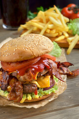 Delicious fresh Burger with double cutlet and French fries on a dark background