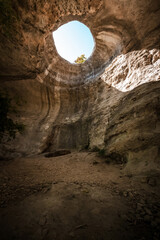 A hole from which the sun's rays and the sky are visible outside of an underground cave, an abnormal natural phenomenon in the rocks in the Crimea