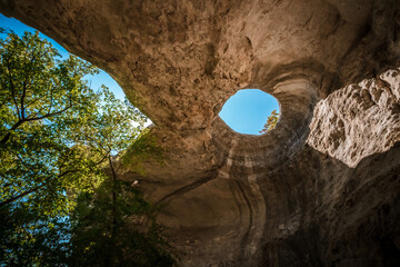 A hole from which the sun's rays and the sky are visible outside of an underground cave, an abnormal natural phenomenon in the rocks in the Crimea