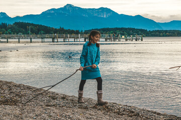 Mädchen spaziert glücklich am See entlang