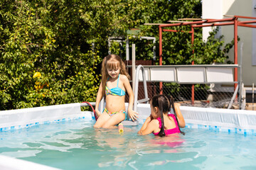 Naklejka premium Kids in swimming pool. Girl swim outdoors.