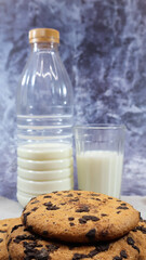 American gluten free chocolate chip cookies with glass glass of vegetable milk on gray background. Chocolate chip cookies. Sweet pastries, dessert. Culinary background. Vertical photography.